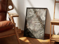 Boneless by Muse and Paw, a painterly print of a grey cat lying flat on its back with paws folded, framed and styled in a sunlit room with a leather armchair and wooden chairs.