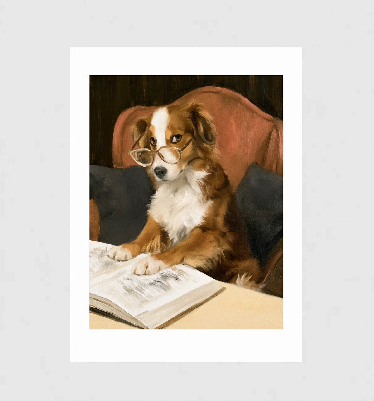 Bookworm by Muse and Paw, a brown and white dog in wire reading glasses reading a book in a red armchair, shown flat as a bordered fine art print.