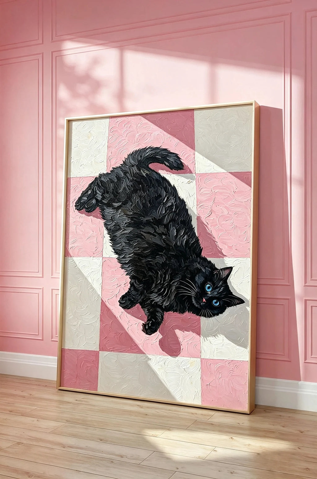 Checkmate black cat and pink checkerboard wall art in a gold frame, leaning against a pink panelled wall on a wooden floor.