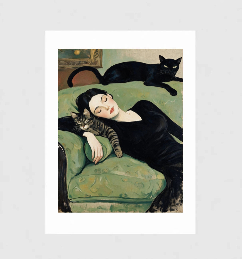 Unbothered by Muse and Paw, a painterly print of a woman asleep on a green chaise with a tabby cat curled in her hand and a black cat stretched along the seat back, framed and leaning against a wall.