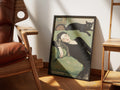 Unbothered by Muse and Paw, a painterly print of a woman asleep on a green chaise with a tabby cat curled in her hand and a black cat stretched along the seat back, styled in a sunlit room with a leather armchair and wooden chairs.